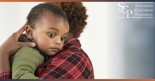 Mother holding baby with scared expression over shoulder